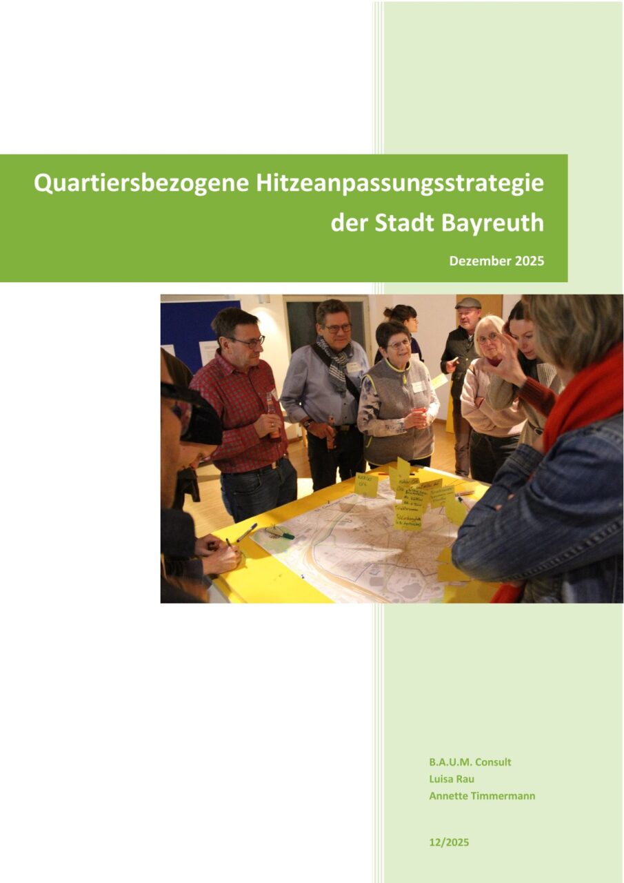 Eine Gruppe von Menschen steht vor einem Tisch, darauf ein Lageplan mit beschrifteten Fähnchen als Markierungspunkte. Im Vordergrund eine Frau, die der Menschengruppe den Plan erklärt. | Foto: Stadt Bayreuth