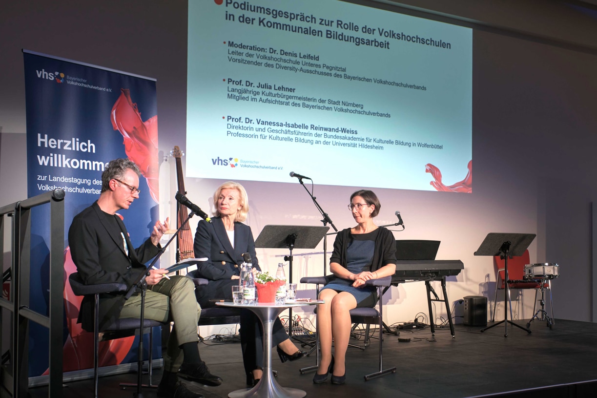 Drei Personen sitzen auf einem Podium und diskutieren. | Foto: