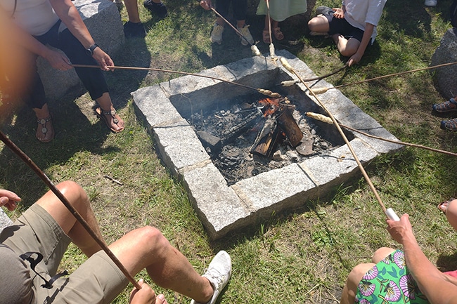 Lagerfeuer, über das Stockbrot gehalten wird