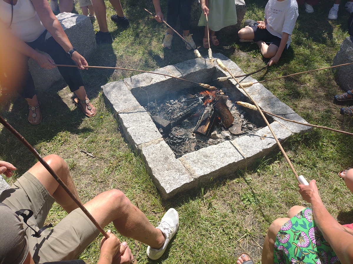 Lagerfeuer, über das Stockbrot gehalten wird