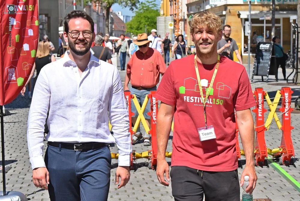 Oberbürgermeister A. Zippel und Projektkoorinador F. Unterburger laufen vor den Sicherheitssperren des Straßenfestes