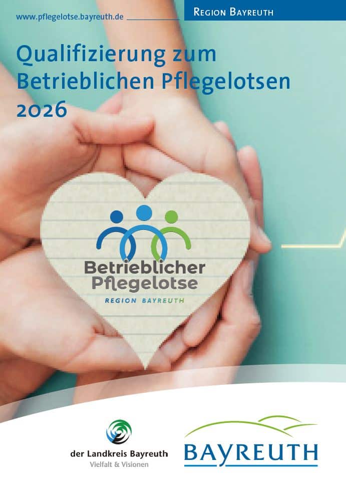 Eine Person hält ein Holzherz in den Händen mit dem Aufdruck "Betrieblicher Pflegelotse"