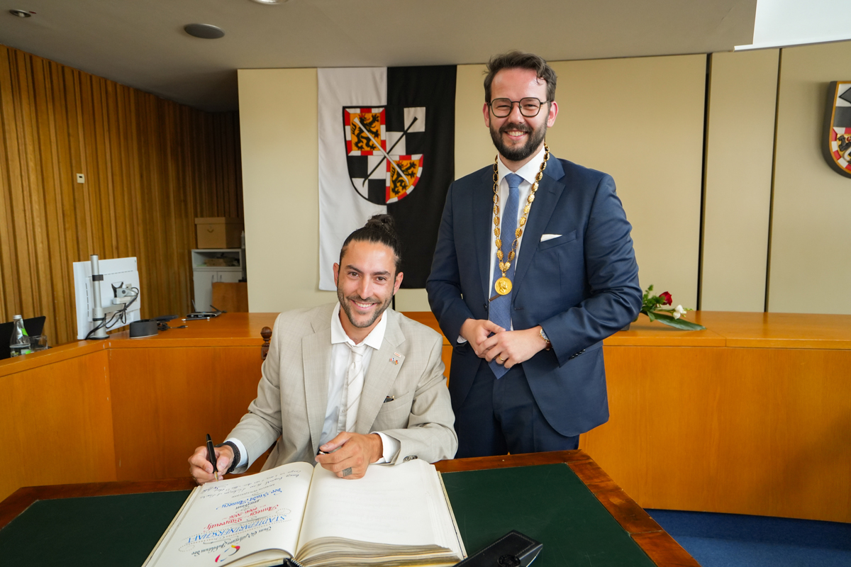 Raphaël Stojic, Stadtrat für internationale Beziehungen und Partnerschaften der Stadt Annecy, trug sich im Beisein von Oberbürgermeister Dr. Andreas Zippel ins Goldene Buch der Stadt Bayreuth ein. Foto: Stadt Bayreuth