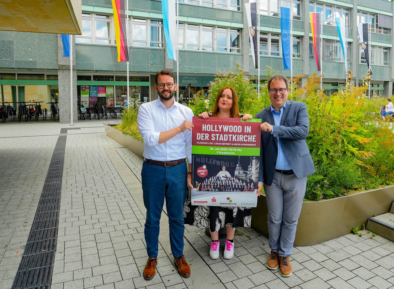 Zwei Männer und eine Frau halten ein Veranstaltungsplakat. | Foto: Stadt Bayreuth