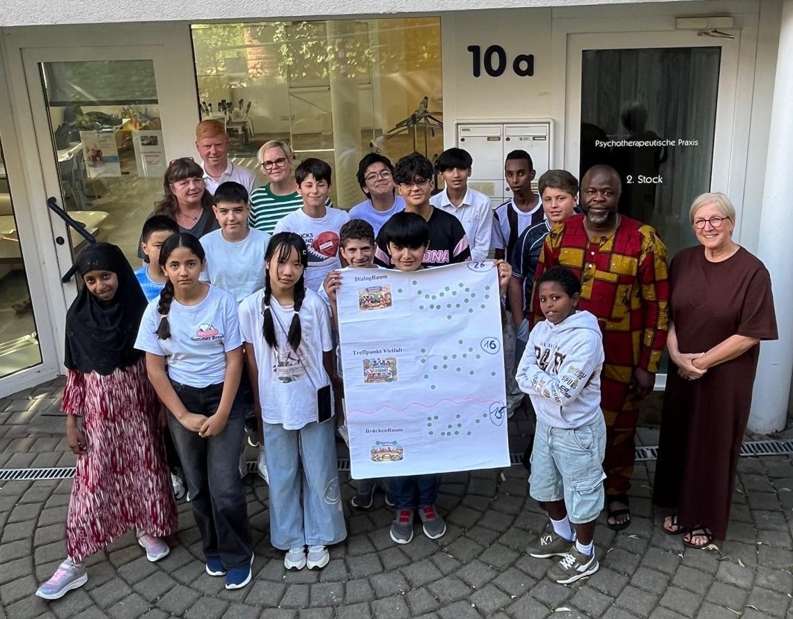 Schülerinnen und Schüler der Altstadtschule stehen mit Lehrkräften vor dem Anwesen Albert-Preu-Straße 10 a und halten ein Plakat hoch. Foto: Stadt Bayreuth