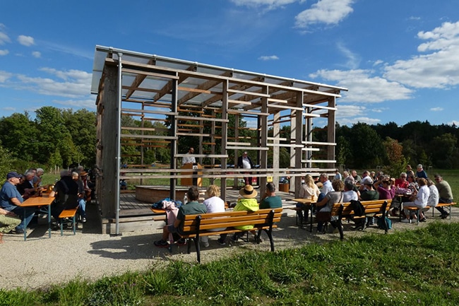 Mehrere Bierbänke, auf denen Menschen sitzen