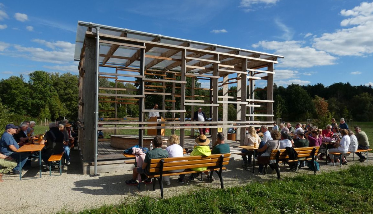 Mehrere Bierbänke, auf denen Menschen sitzen